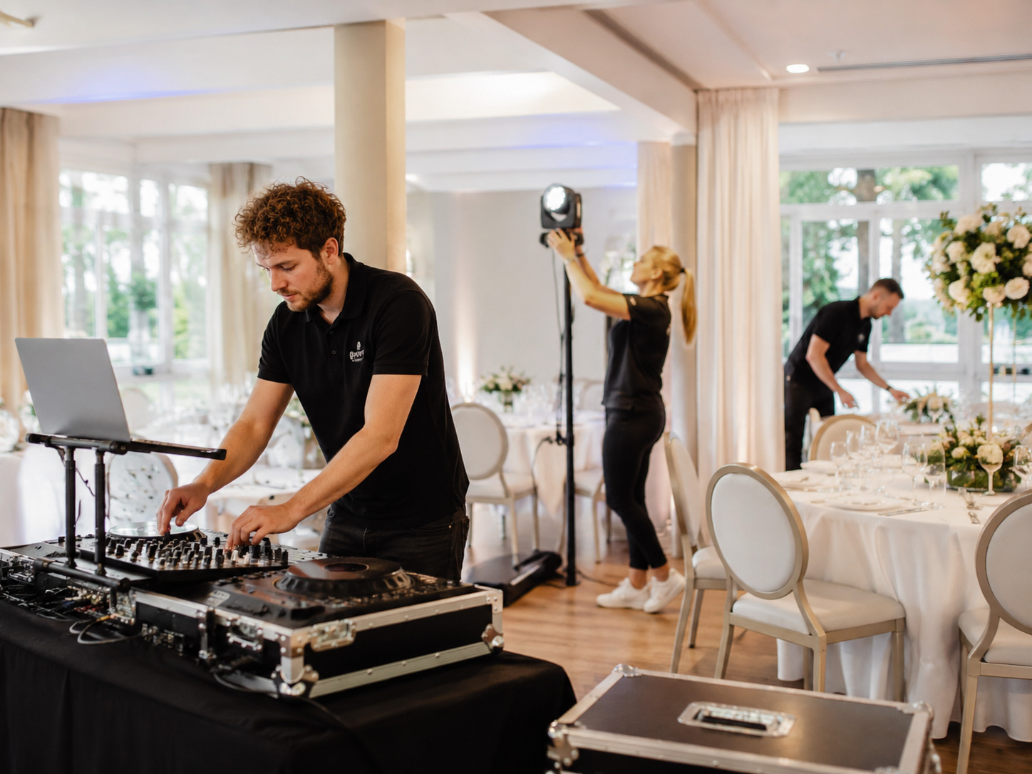 DJ und Eventteam bereiten Technik, Licht und Dekoration für eine Hochzeitslocation vor